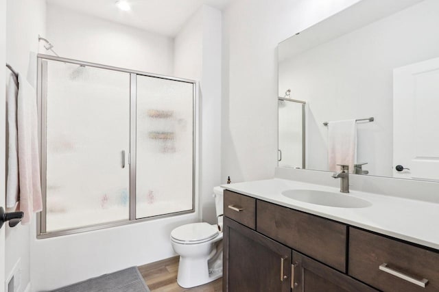 W139S9977 Jay Dr, Muskego, WI 53150 - full bath with shower / bath combination with glass door, wood finished floors, vanity, and toilet