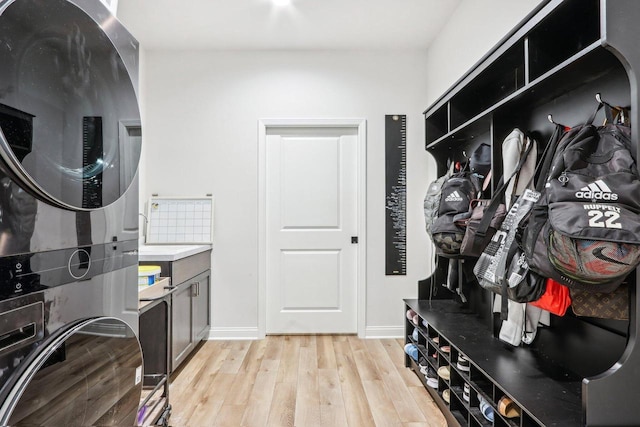 W139S9977 Jay Dr, Muskego, WI 53150 - laundry area with stacked washer / dryer, light wood-style flooring, and baseboards