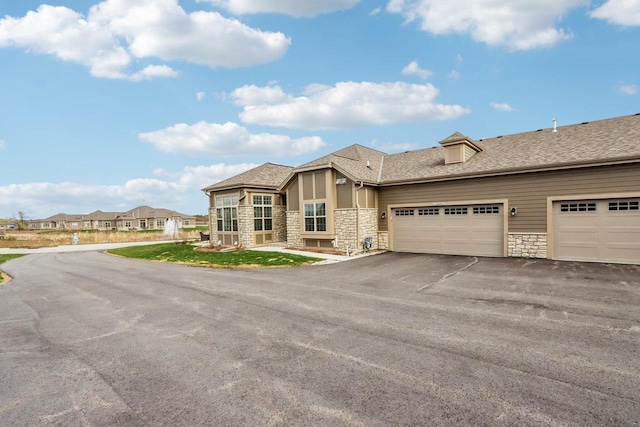W139S9977 Jay Dr, Muskego, WI 53150 - view of front of house featuring stone siding, asphalt driveway, an attached garage, and roof with shingles