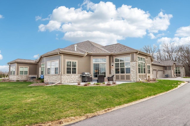 W139S9977 Jay Dr, Muskego, WI 53150 - rear view of house with stone siding, a yard, and driveway