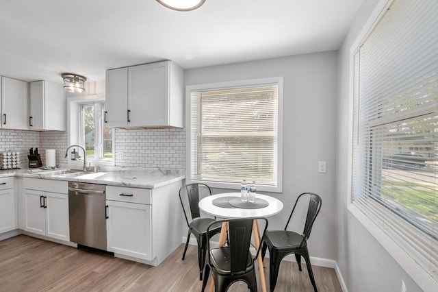 1201 Redwood Dr, Green Bay, WI 54304 - kitchen with dishwasher, a sink, backsplash, light wood-style floors, and white cabinetry
