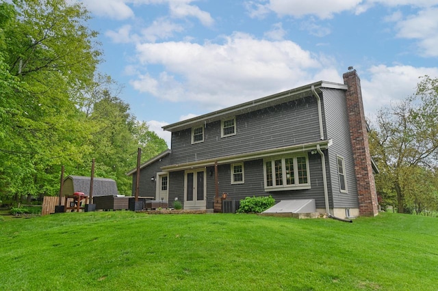 5458 Cascade Dr, West Bend, WI 53095 - rear view of property featuring a chimney and a lawn