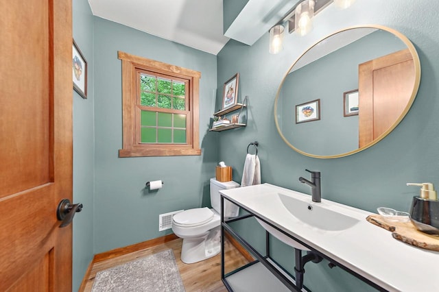 5458 Cascade Dr, West Bend, WI 53095 - half bath with wood finished floors, vanity, toilet, and baseboards