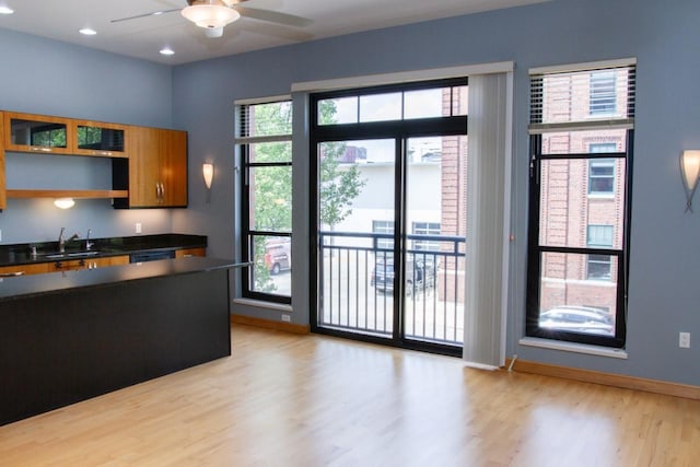 615 W Main St Unit 205, Madison, WI 53703 - kitchen featuring a ceiling fan, light wood-type flooring, dark countertops, a sink, and baseboards