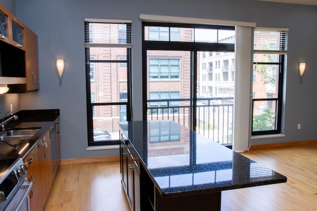 615 W Main St Unit 205, Madison, WI 53703 - kitchen with a sink, light wood finished floors, baseboards, appliances with stainless steel finishes, and a center island