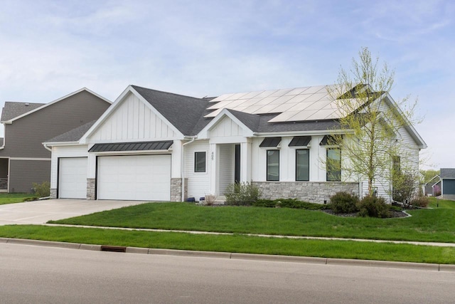 modern farmhouse style home featuring board and batten siding, stone siding, a garage, and a front yard