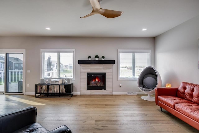 living room with wood-type flooring, plenty of natural light, ceiling fan, baseboards, and recessed lighting