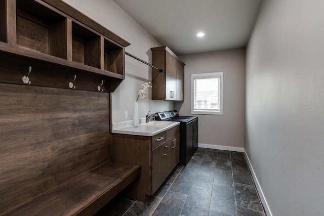 laundry room featuring cabinet space, baseboards, washing machine and dryer, and recessed lighting