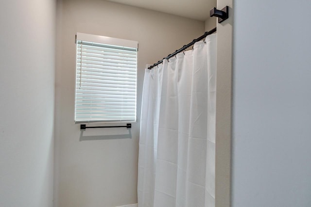 bathroom with curtained shower and plenty of natural light