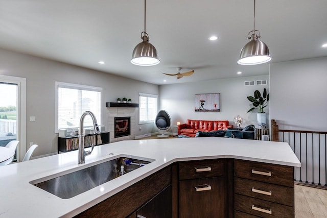 kitchen featuring a sink, open floor plan, light countertops, and recessed lighting