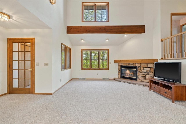 5287 Pleasant Hill Rd, Hartford, WI 53027 - unfurnished living room with carpet floors, baseboards, a stone fireplace, beamed ceiling, and high vaulted ceiling