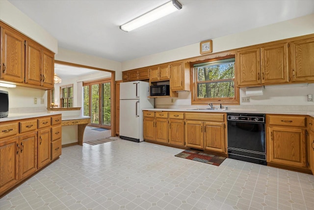 5287 Pleasant Hill Rd, Hartford, WI 53027 - kitchen with black appliances, light countertops, a sink, and healthy amount of natural light
