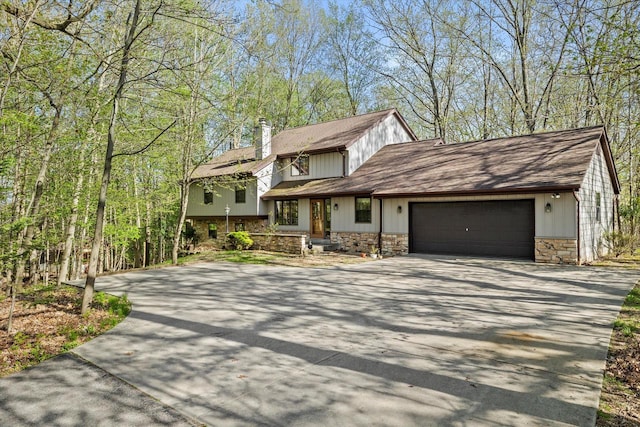 5287 Pleasant Hill Rd, Hartford, WI 53027 - view of front facade with driveway, stone siding, a chimney, an attached garage, and a shingled roof