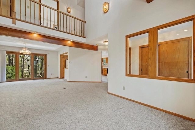 5287 Pleasant Hill Rd, Hartford, WI 53027 - unfurnished living room featuring carpet floors, baseboards, a high ceiling, and a chandelier