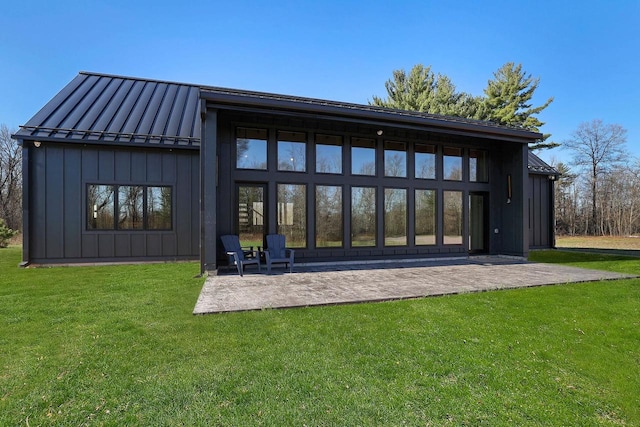 W4310 33rd St, Necedah, WI 54646 - rear view of property featuring a standing seam roof, board and batten siding, a patio area, a yard, and metal roof