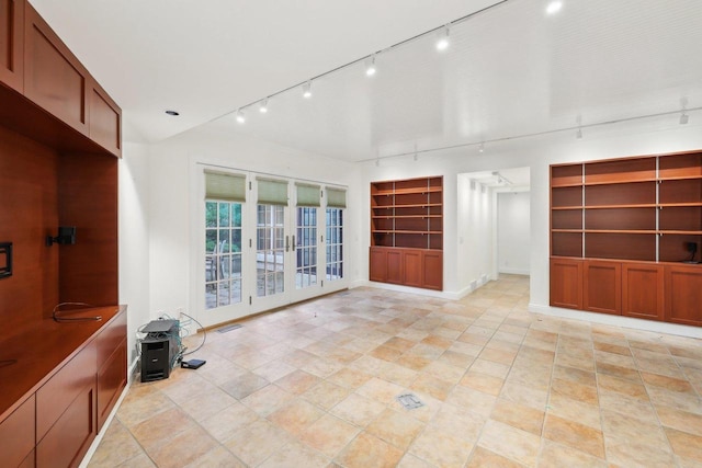 923 Swarthmore Ct, Madison, WI 53705 - unfurnished living room with rail lighting, built in features, and baseboards