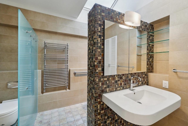923 Swarthmore Ct, Madison, WI 53705 - bathroom with tile walls, radiator heating unit, a sink, toilet, and a towel warming rack