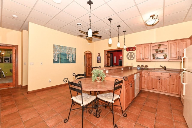 7601 S Cambridge Dr, Franklin, WI 53132 - kitchen featuring a peninsula, open shelves, arched walkways, dishwasher, and dark tile patterned flooring