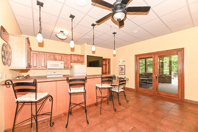 7601 S Cambridge Dr, Franklin, WI 53132 - kitchen with white appliances, a paneled ceiling, hanging light fixtures, baseboards, and a breakfast bar