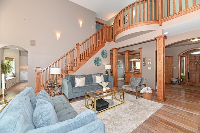 7601 S Cambridge Dr, Franklin, WI 53132 - living area featuring a high ceiling, arched walkways, stairs, and wood-type flooring