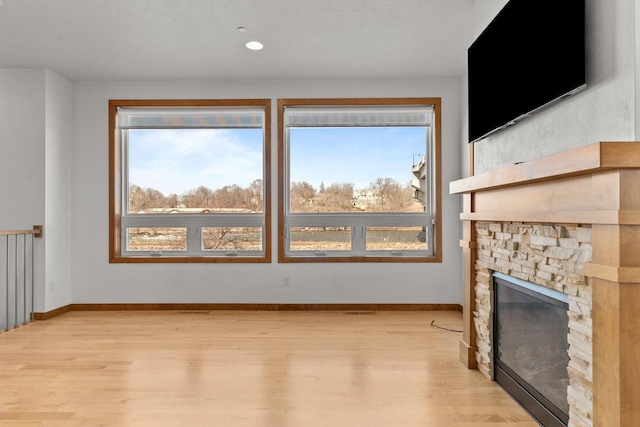 1141 E Banta Ct, Appleton, WI 54914 - unfurnished living room with a fireplace, light wood-style floors, and baseboards