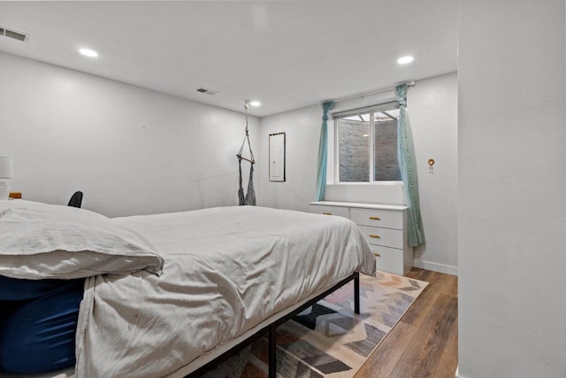 bedroom featuring wood finished floors, recessed lighting, and baseboards