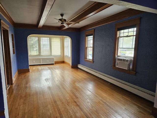 3513 Washington Ave, Racine, WI 53405 - spare room featuring a textured wall, beam ceiling, a baseboard radiator, arched walkways, and healthy amount of natural light
