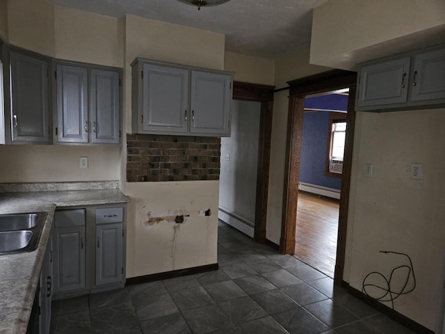 3513 Washington Ave, Racine, WI 53405 - kitchen featuring baseboard heating, gray cabinetry, and light countertops