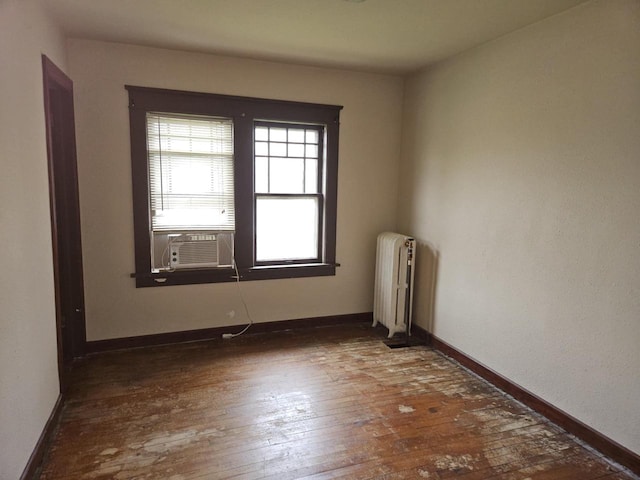 3513 Washington Ave, Racine, WI 53405 - empty room featuring radiator, cooling unit, hardwood / wood-style flooring, and baseboards