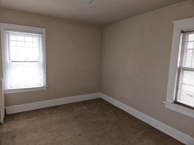 3513 Washington Ave, Racine, WI 53405 - empty room featuring dark colored carpet and baseboards