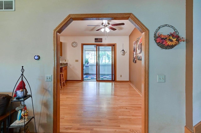 entryway featuring light wood-style floors, a ceiling fan, and baseboards