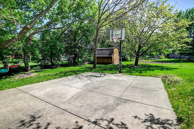 view of sport court featuring a storage shed and a lawn