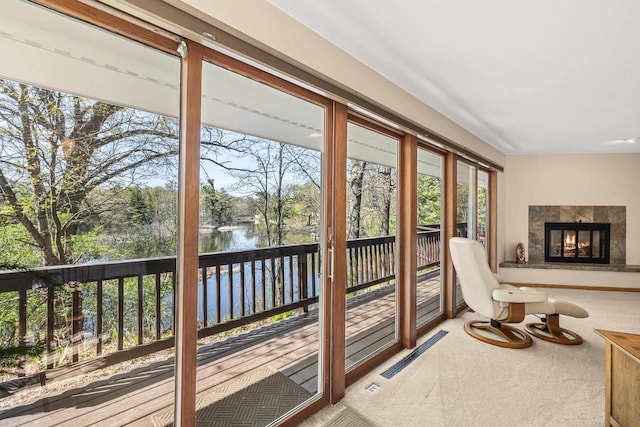 528 Park Ave, Waupaca, WI 54981 - entryway with a water view, a tiled fireplace, carpet floors, and plenty of natural light