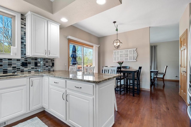 W6928 Westwood Dr, Fond Du Lac, WI 54937 - kitchen featuring a peninsula, dark wood-style floors, white cabinets, tasteful backsplash, and recessed lighting
