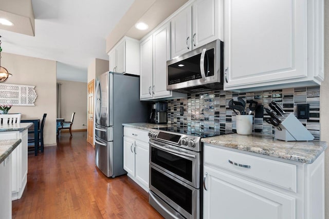 W6928 Westwood Dr, Fond Du Lac, WI 54937 - kitchen featuring stainless steel appliances, white cabinetry, decorative backsplash, wood finished floors, and recessed lighting
