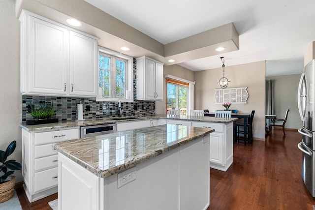 W6928 Westwood Dr, Fond Du Lac, WI 54937 - kitchen featuring a peninsula, freestanding refrigerator, a center island, dark wood-type flooring, and white cabinets