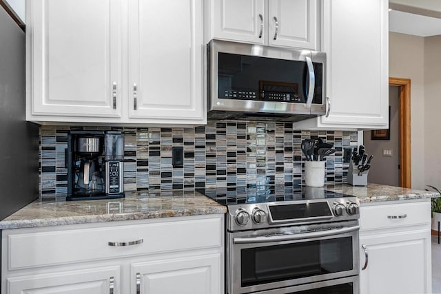 W6928 Westwood Dr, Fond Du Lac, WI 54937 - kitchen featuring stainless steel appliances, decorative backsplash, white cabinets, and light stone countertops