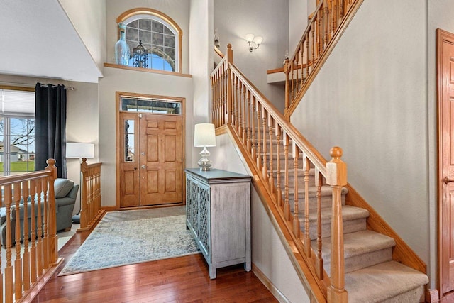 W6928 Westwood Dr, Fond Du Lac, WI 54937 - foyer featuring hardwood / wood-style flooring, stairs, a towering ceiling, and baseboards