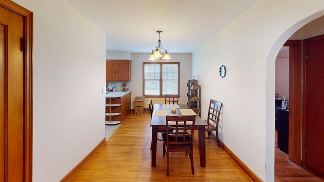 5869 State Highway 27, Sparta, WI 54656 - dining room with light wood-style flooring, arched walkways, and baseboards