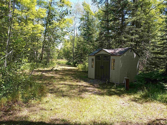 23540 State Highway 13, Cornucopia, WI 54827 - view of yard featuring a storage unit, an outdoor structure, and a forest view