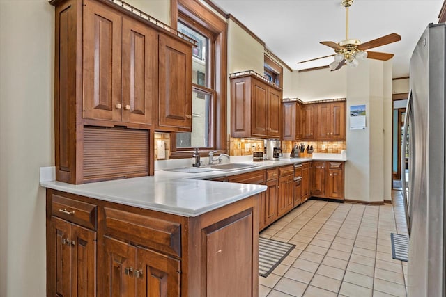 2837 N Marietta Ave, Milwaukee, WI 53211 - kitchen with a sink, freestanding refrigerator, ceiling fan, a peninsula, and light tile patterned flooring