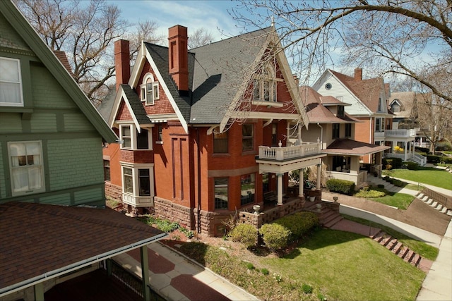 2837 N Marietta Ave, Milwaukee, WI 53211 - view of property exterior featuring a chimney, stone siding, a balcony, a shingled roof, and brick siding