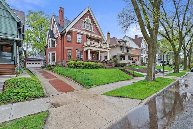 2837 N Marietta Ave, Milwaukee, WI 53211 - view of front of property with brick siding, a front lawn, a residential view, a garage, and a balcony