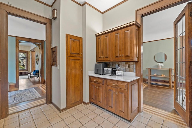 2837 N Marietta Ave, Milwaukee, WI 53211 - kitchen featuring brown cabinetry, baseboards, ornamental molding, light countertops, and light tile patterned floors