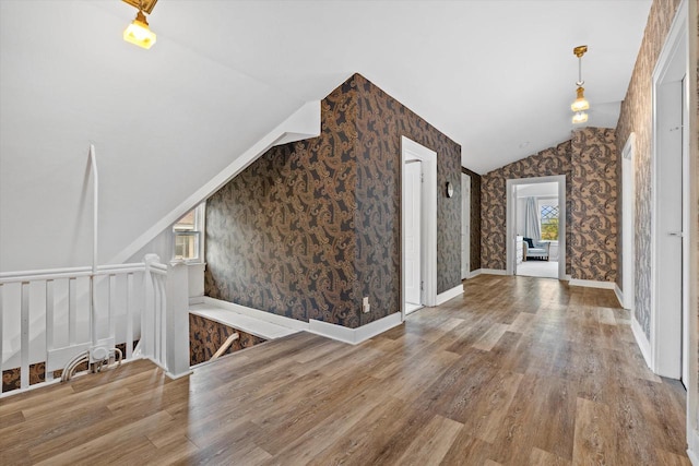 2837 N Marietta Ave, Milwaukee, WI 53211 - unfurnished living room featuring wallpapered walls, lofted ceiling, wood finished floors, and baseboards