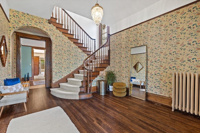 2837 N Marietta Ave, Milwaukee, WI 53211 - staircase featuring radiator, wallpapered walls, wood finished floors, wainscoting, and arched walkways