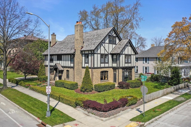 304 16th St, Racine, WI 53403 - tudor house featuring a chimney, brick siding, and stucco siding