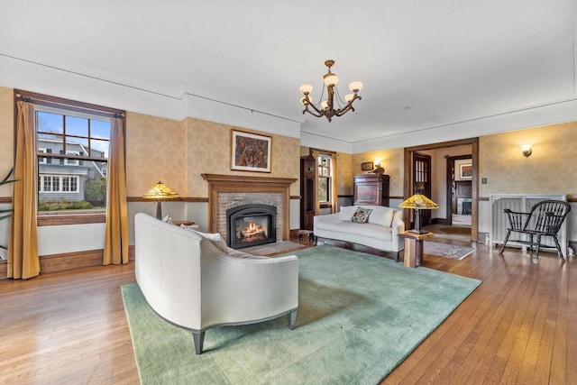 304 16th St, Racine, WI 53403 - living area with a glass covered fireplace, a chandelier, wood-type flooring, and baseboards