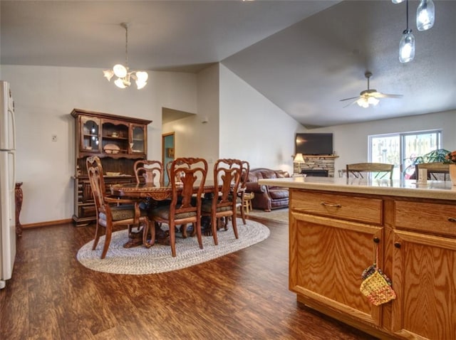 429 Riggs St, Bloomer, WI 54724 - dining room with lofted ceiling, dark wood-style floors, a fireplace, a ceiling fan, and a chandelier