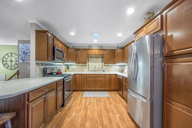 528 High St, Walworth, WI 53184 - kitchen featuring stainless steel appliances, a sink, ornamental molding, tasteful backsplash, and light wood finished floors
